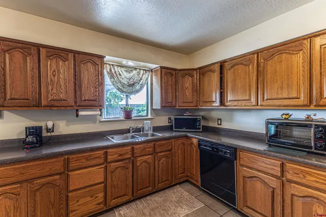 a kitchen with stainless steel appliances granite countertop a sink dishwasher stove and cabinets