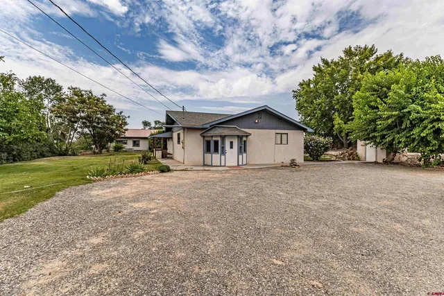 a view of a house with a yard and sitting area