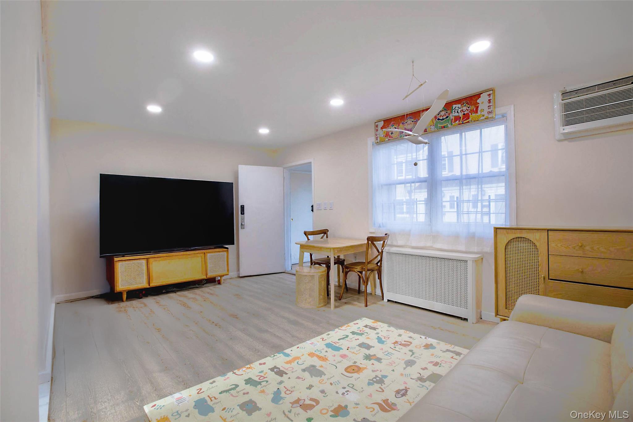 64-55 Springfield Boulevard, Unit 6455 Queens, NY 11364 - Photo 4 of 14 a living room with furniture and a flat screen tv