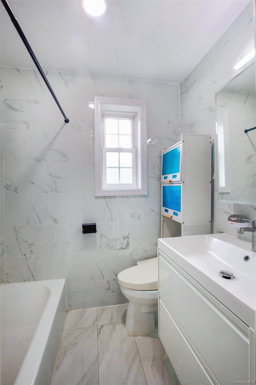 64-55 Springfield Boulevard, Unit 6455 Queens, NY 11364 - Photo 8 of 14 a bathroom with a sink a toilet and a bathtub