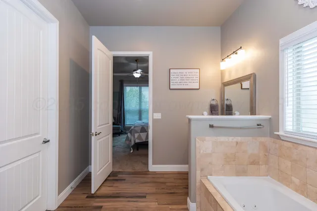 a bathroom with a bathtub a mirror and a sink