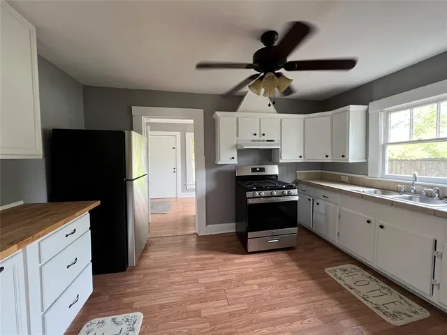 a kitchen with a refrigerator a sink and cabinets
