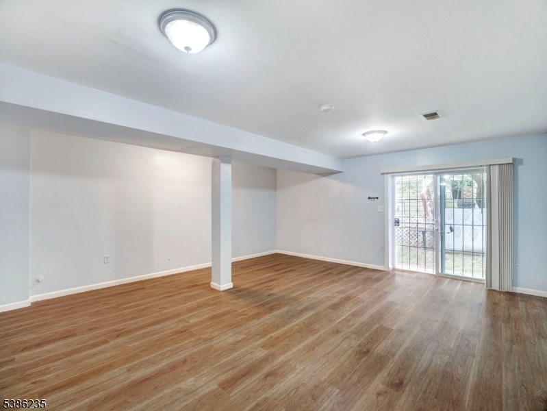 33 Kent Street Newark, NJ 07108 - Photo 4 of 12 an empty room with wooden floor and windows