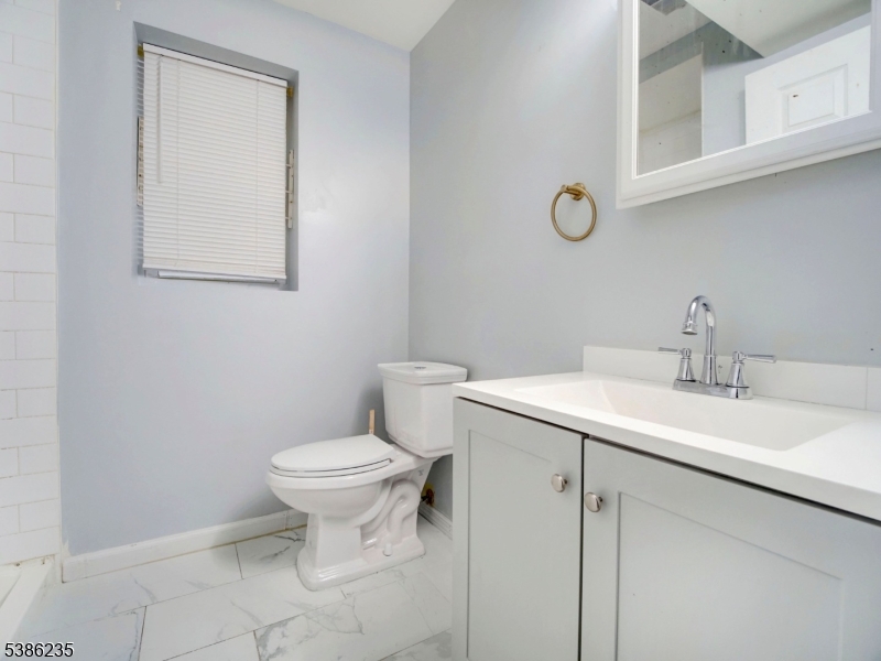 33 Kent Street Newark, NJ 07108 - Photo 10 of 12 a bathroom with a toilet sink and mirror