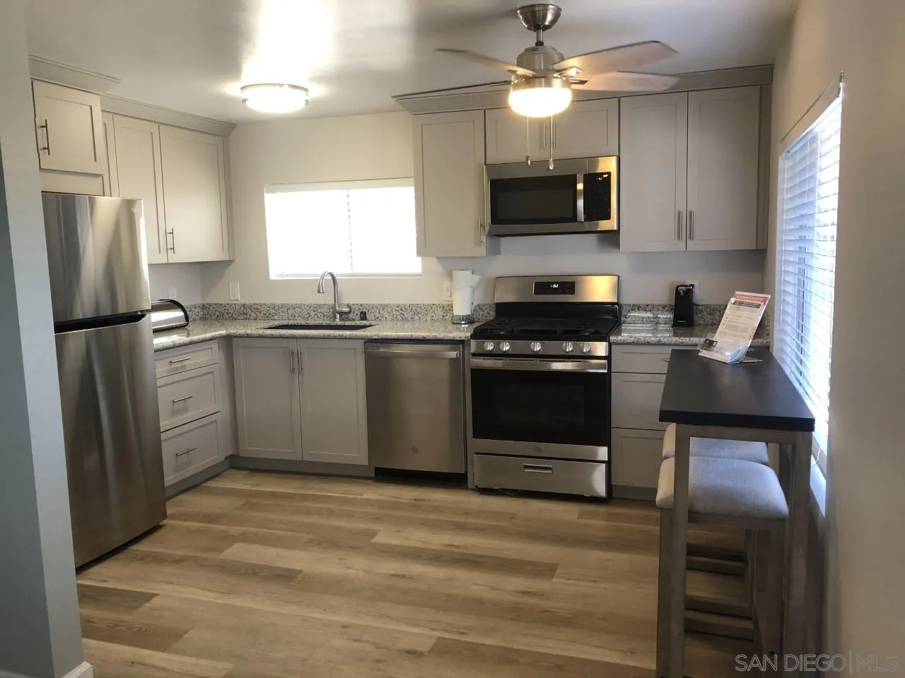 9459 Mission Gorge Road, Unit 13 Santee, CA 92071 - Photo 3 of 11 a kitchen with stainless steel appliances granite countertop a stove top oven a refrigerator and a sink