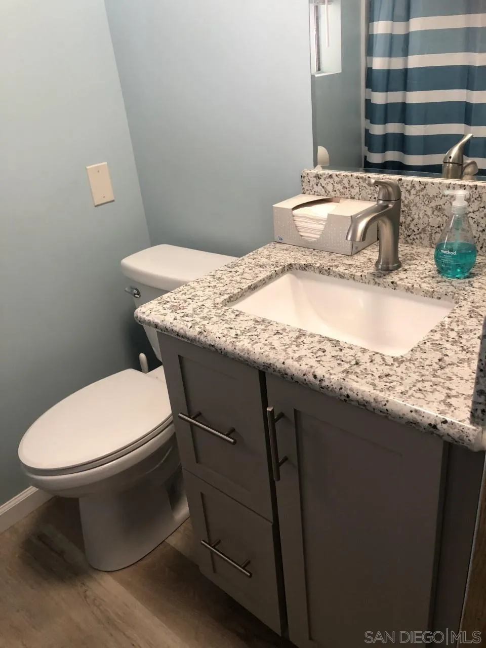 9459 Mission Gorge Road, Unit 13 Santee, CA 92071 - Photo 8 of 11 a bathroom with a granite countertop toilet sink and mirror