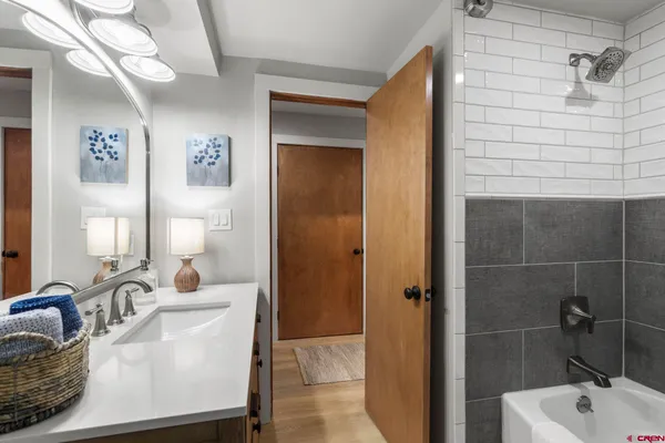 a bathroom with a tub a sink and mirror