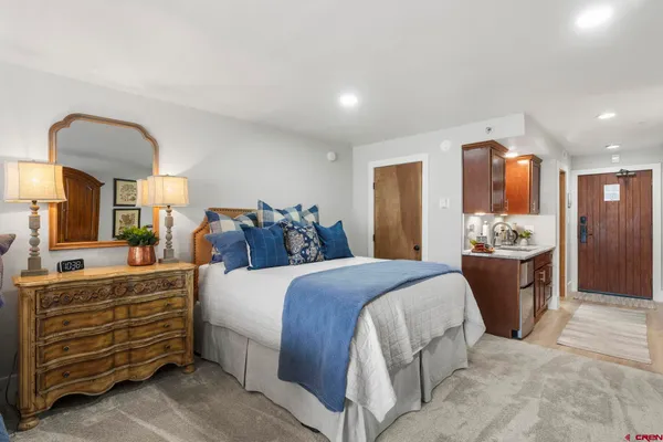 a bedroom with a large bed and a dresser
