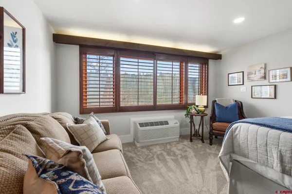 a spacious bedroom with a bed and glass windows