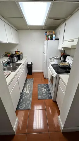 a kitchen with a stove and white cabinets