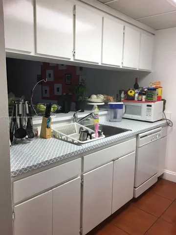 a kitchen with appliances a sink and cabinets