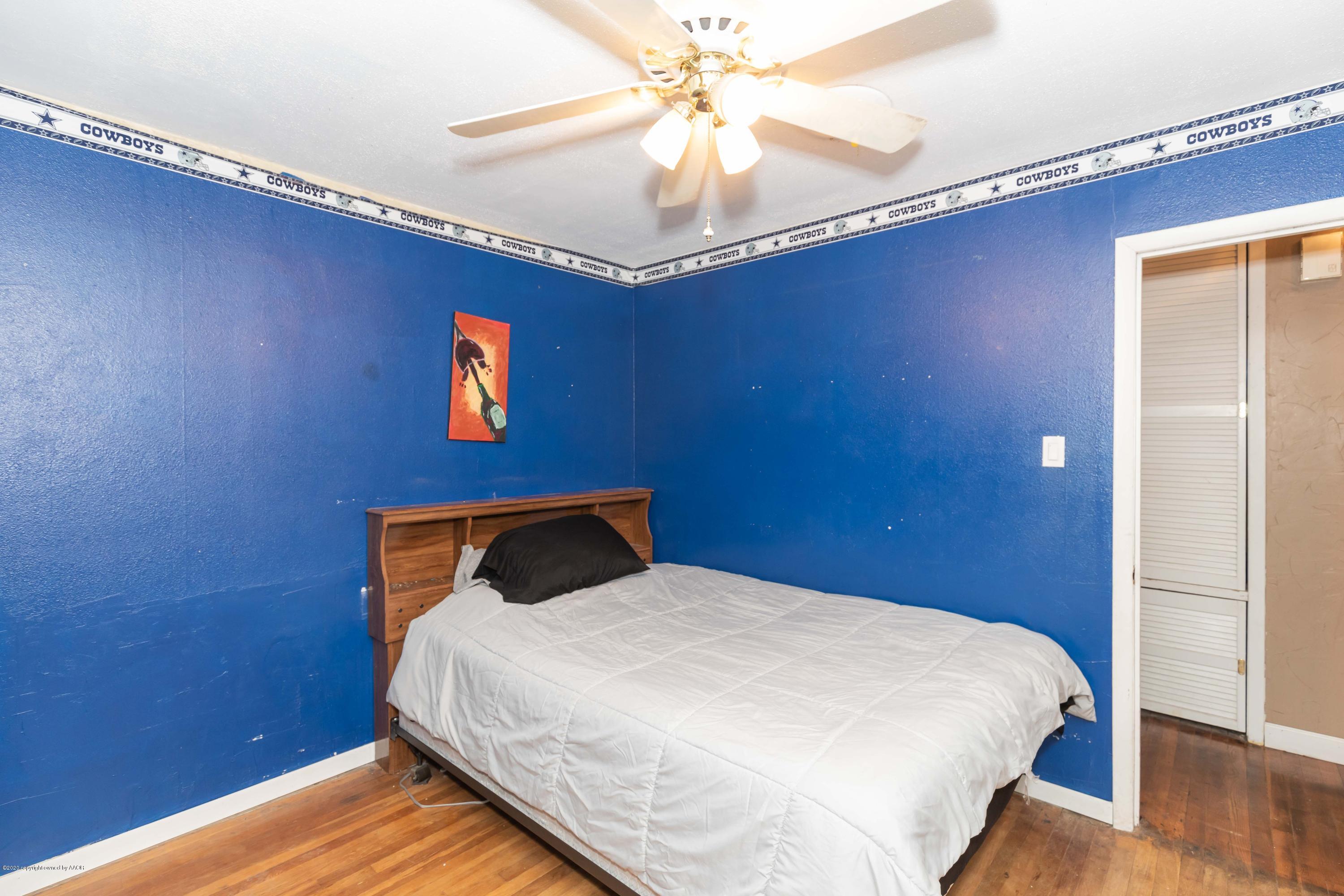 3610 South Travis Street Amarillo, TX 79110 - Photo 27 of 39 a bedroom with a bed and a chandelier
