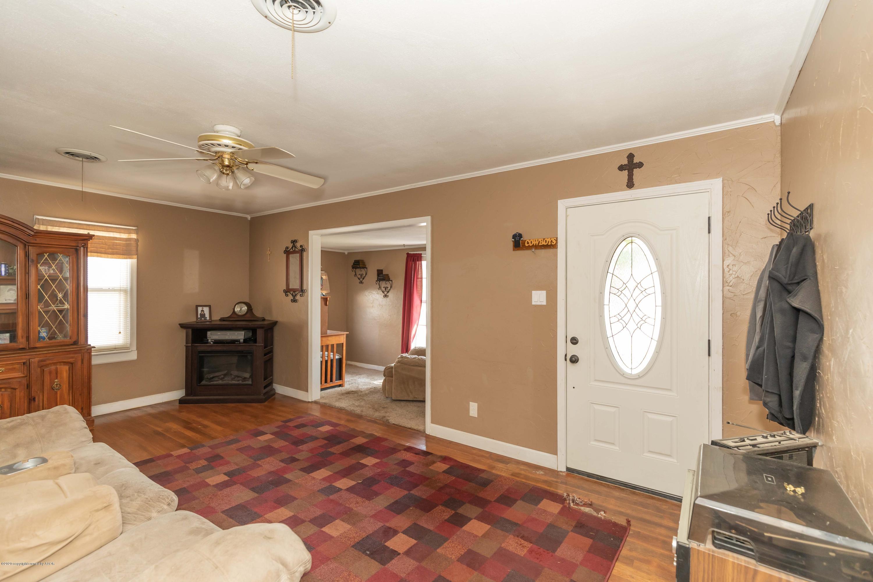 3610 South Travis Street Amarillo, TX 79110 - Photo 7 of 39 a living room with furniture a fireplace and a chandelier