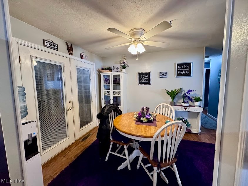 240 Spring Creek Road Northfield, OH 44067 - Photo 7 of 39 Dining space featuring french doors, a textured ceiling, dark hardwood / wood-style flooring, and ceiling fan