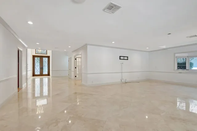 a view of a big room with wooden floor kitchen view and windows