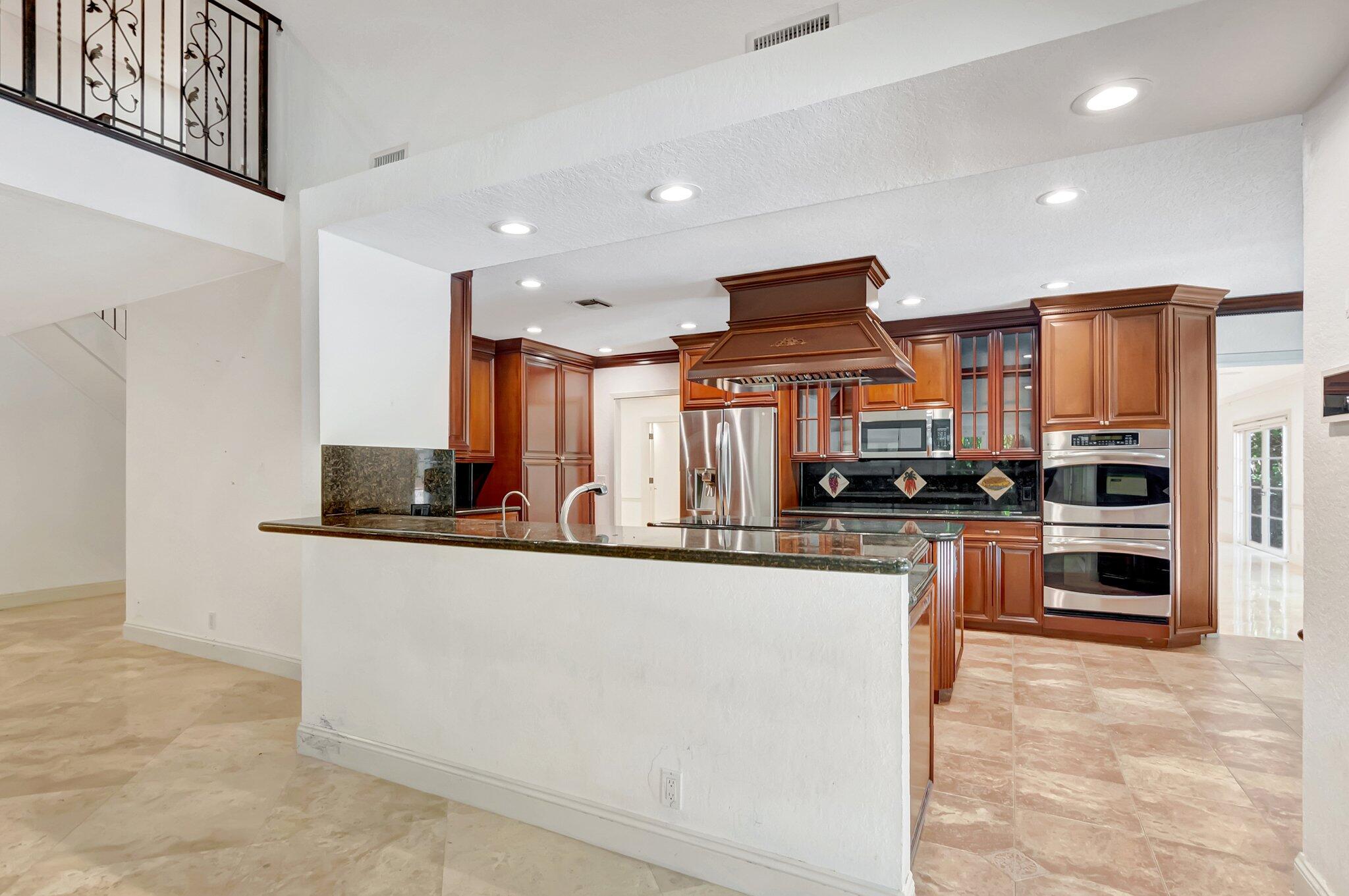 930 Parkside Circle North Boca Raton, FL 33486 - Photo 29 of 81 a kitchen with stainless steel appliances granite countertop a stove top oven a sink and dishwasher