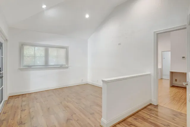 a view of a hallway with wooden floor and stairs