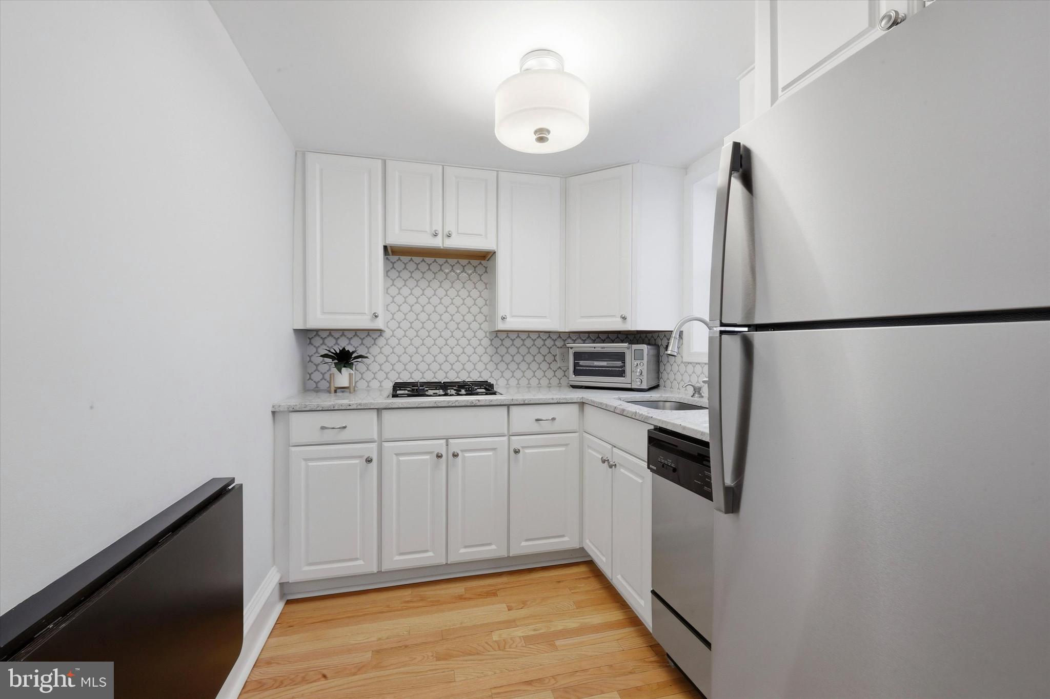 1917 Rodman Street Philadelphia, PA 19146 - Photo 6 of 31 a kitchen with white cabinets and white appliances