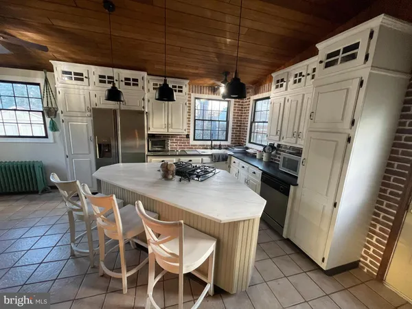 a kitchen with stainless steel appliances a stove a refrigerator and a dining table