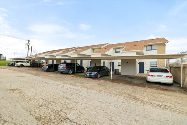 a view of parking with cars parked in front of it