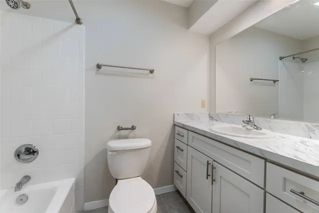 a bathroom with a granite countertop toilet sink and mirror