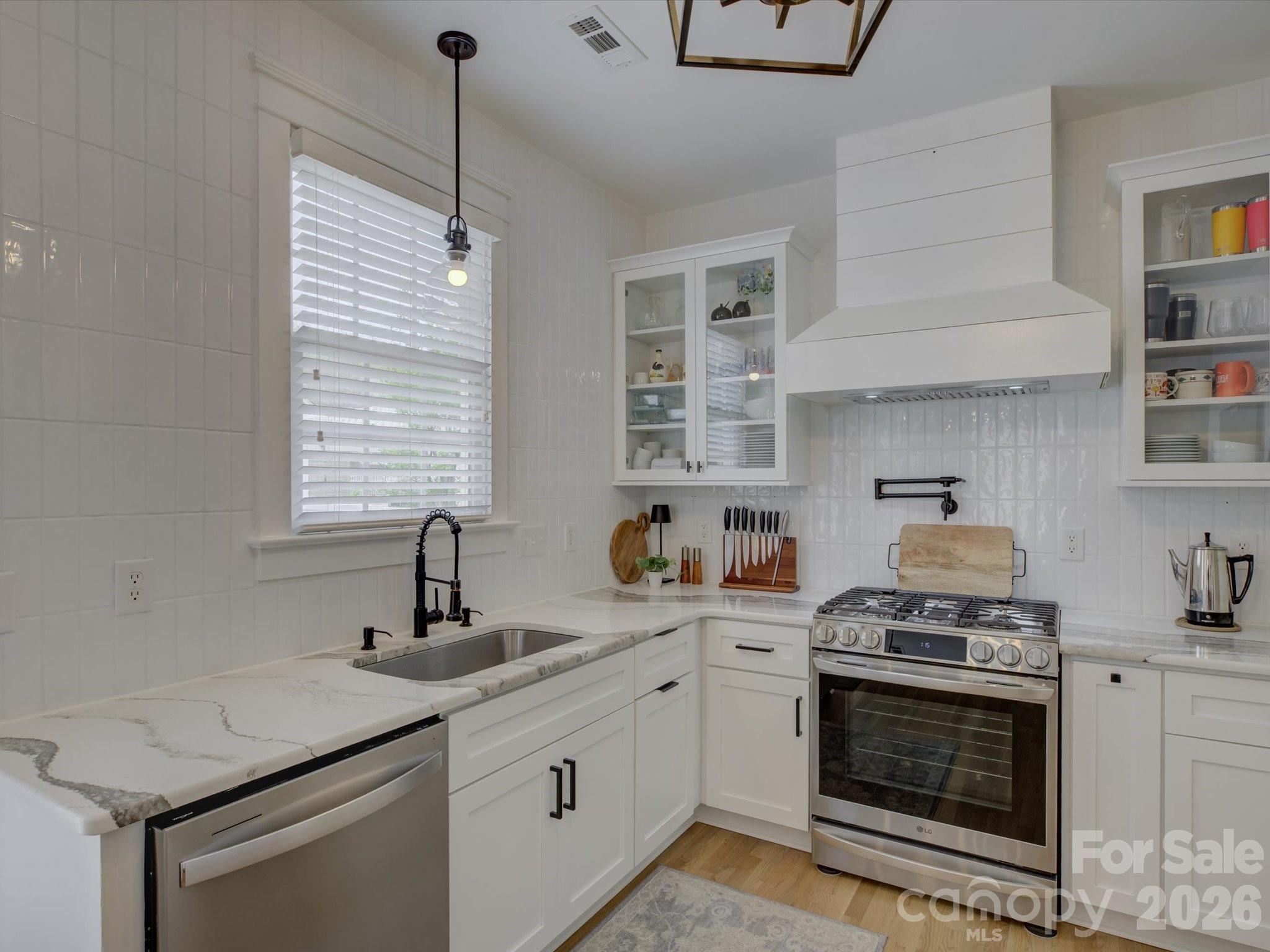 1305 Barnett Woods Crossing Fort Mill, SC 29708 - Photo 13 of 48 a kitchen with stainless steel appliances granite countertop a sink stove and cabinets
