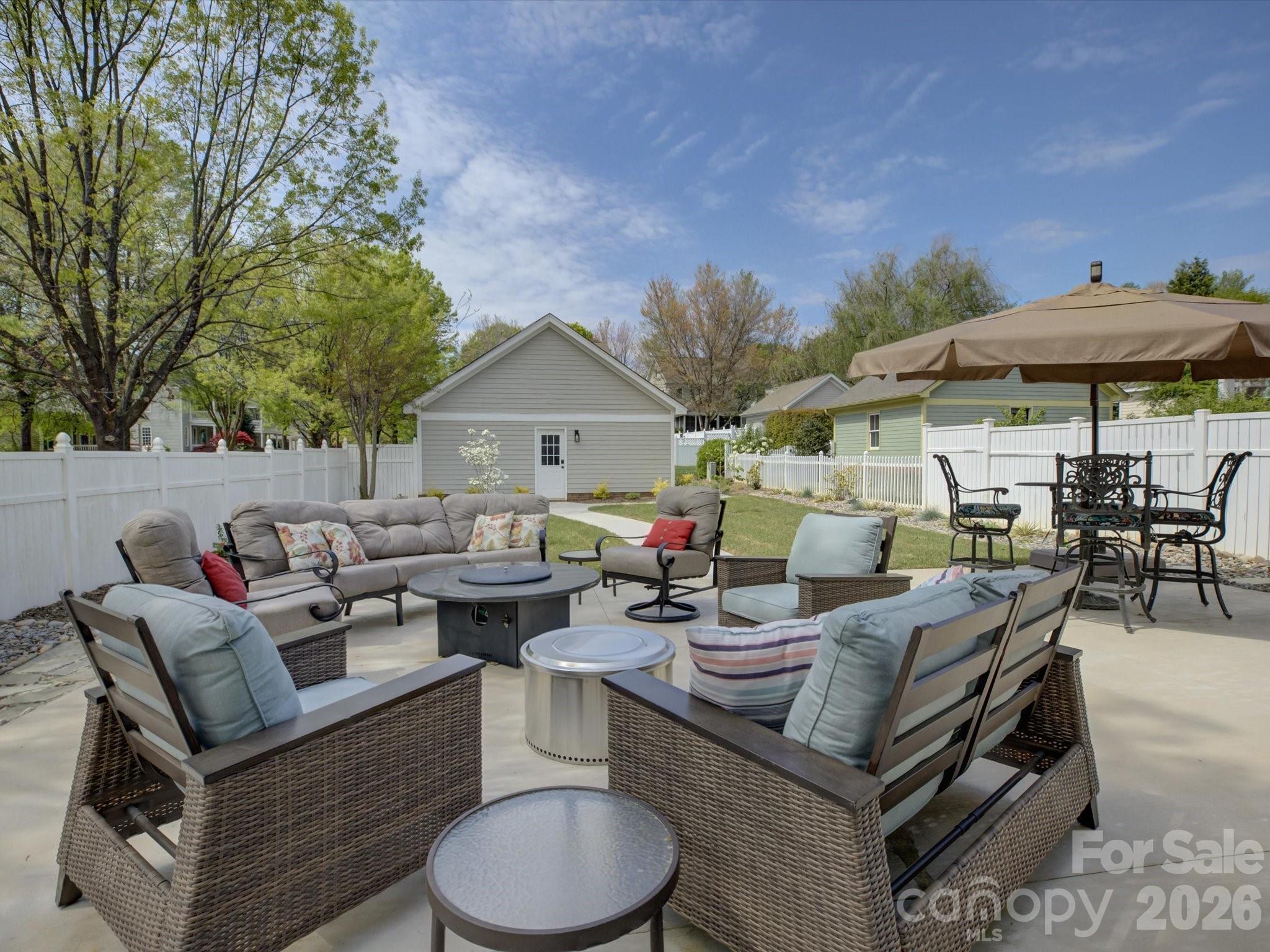 1305 Barnett Woods Crossing Fort Mill, SC 29708 - Photo 42 of 48 a view of a patio with a dining table and chairs under an umbrella