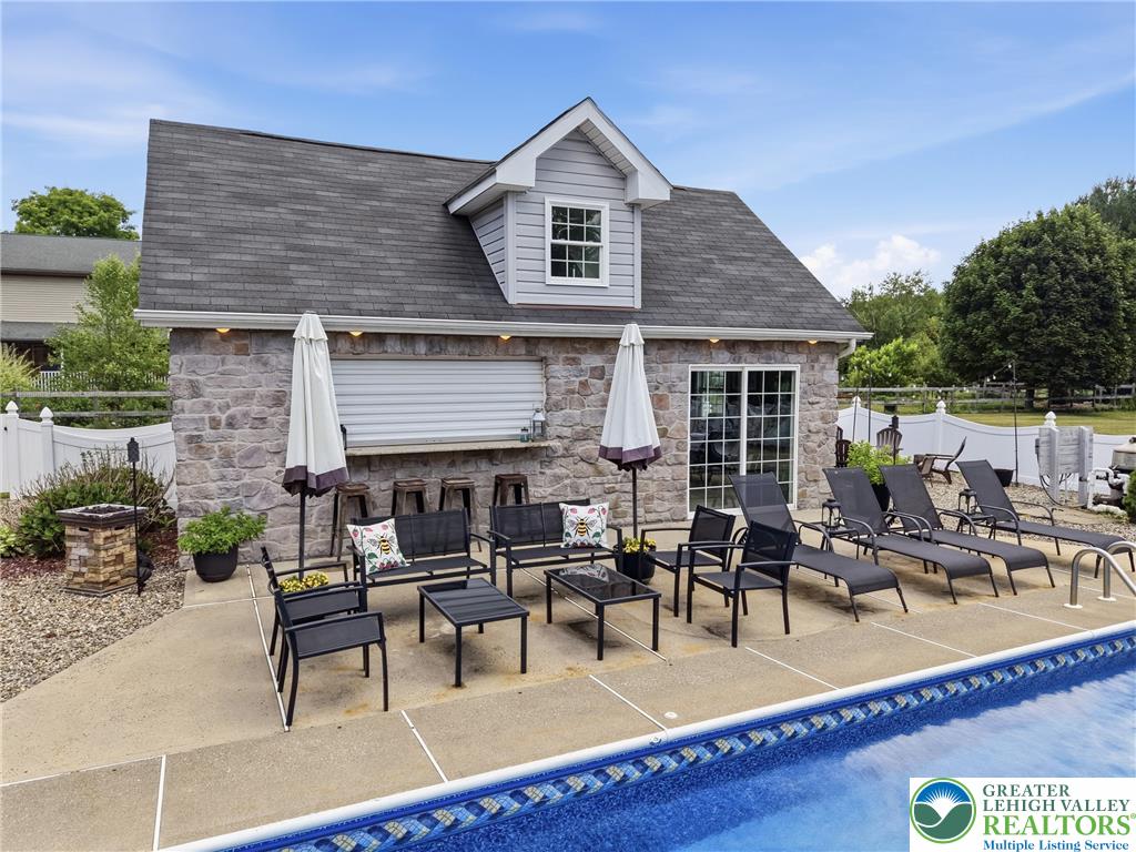 890 Lahr Road Nazareth, PA 18064 - Photo 49 of 71 An inviting poolside retreat awaits with a charming stone-faced structure and comfortable lounge seating.