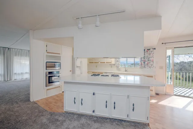 a view of an empty room with window and cabinet