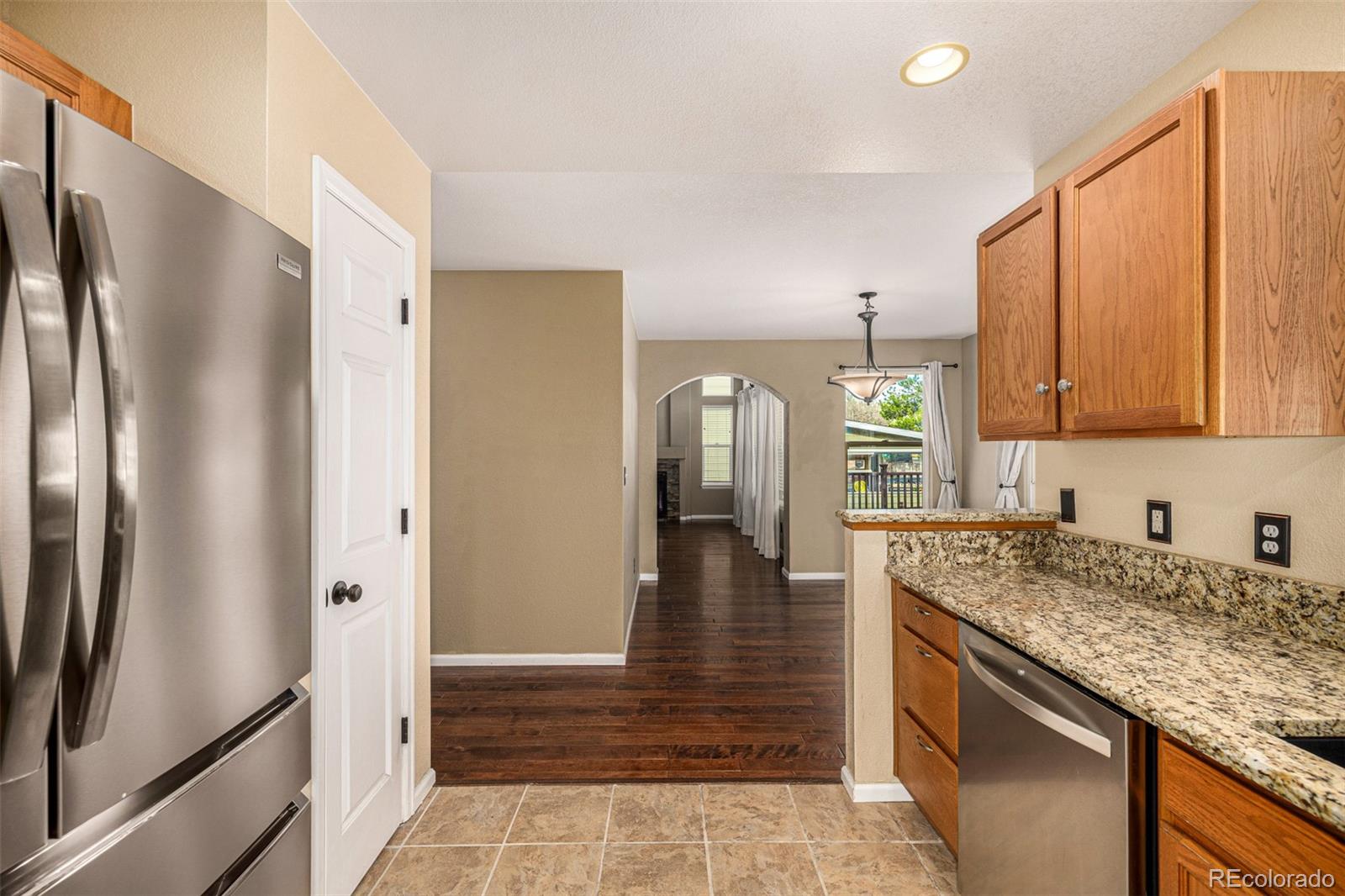 10244 Royal Eagle Street Highlands Ranch, CO 80129 - Photo 17 of 46 a kitchen with stainless steel appliances granite countertop a refrigerator and a sink