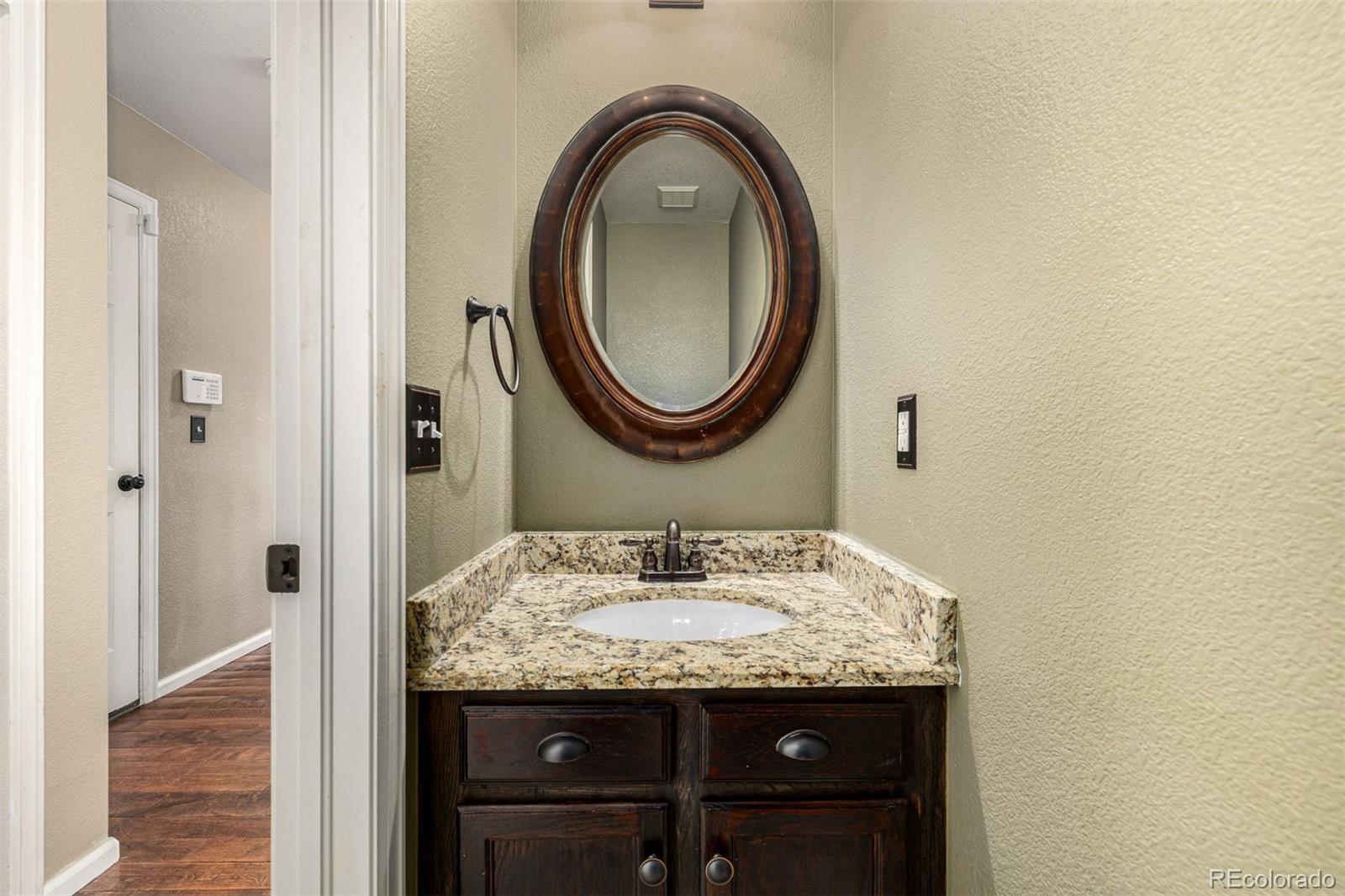 10244 Royal Eagle Street Highlands Ranch, CO 80129 - Photo 20 of 46 a bathroom with a granite countertop sink and a mirror