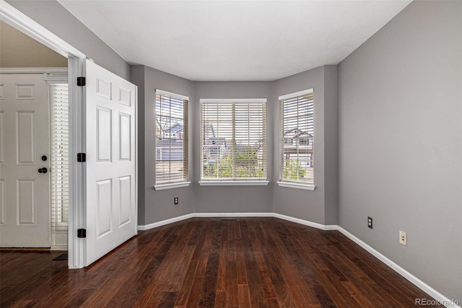 10244 Royal Eagle Street Highlands Ranch, CO 80129 - Photo 7 of 46 a view of an empty room with wooden floor and a window