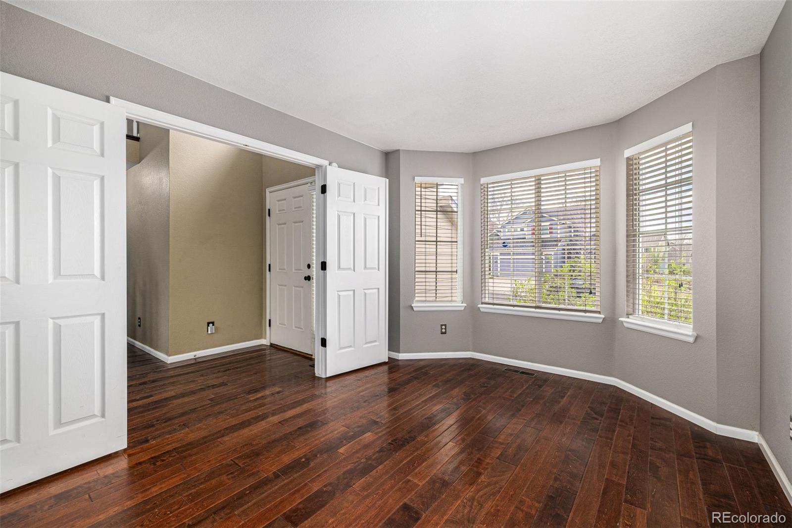 10244 Royal Eagle Street Highlands Ranch, CO 80129 - Photo 9 of 46 a view of an empty room with wooden floor and a window