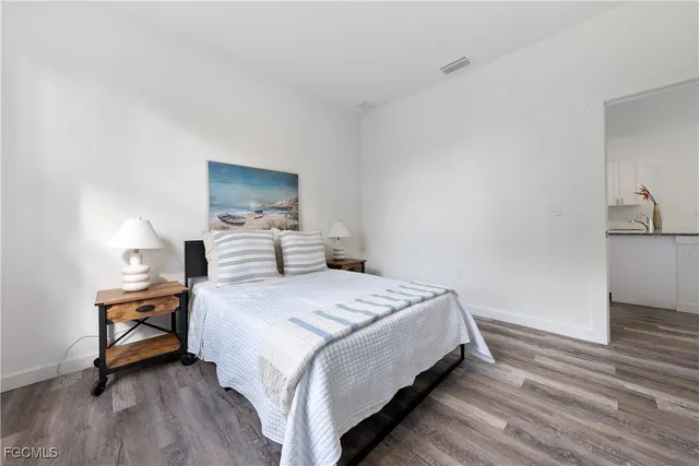 a bedroom with a bed and wooden floor