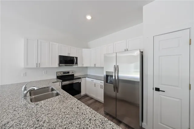 a kitchen with a refrigerator a stove top oven a sink and dishwasher