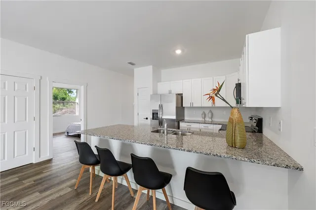a kitchen with a sink and chairs