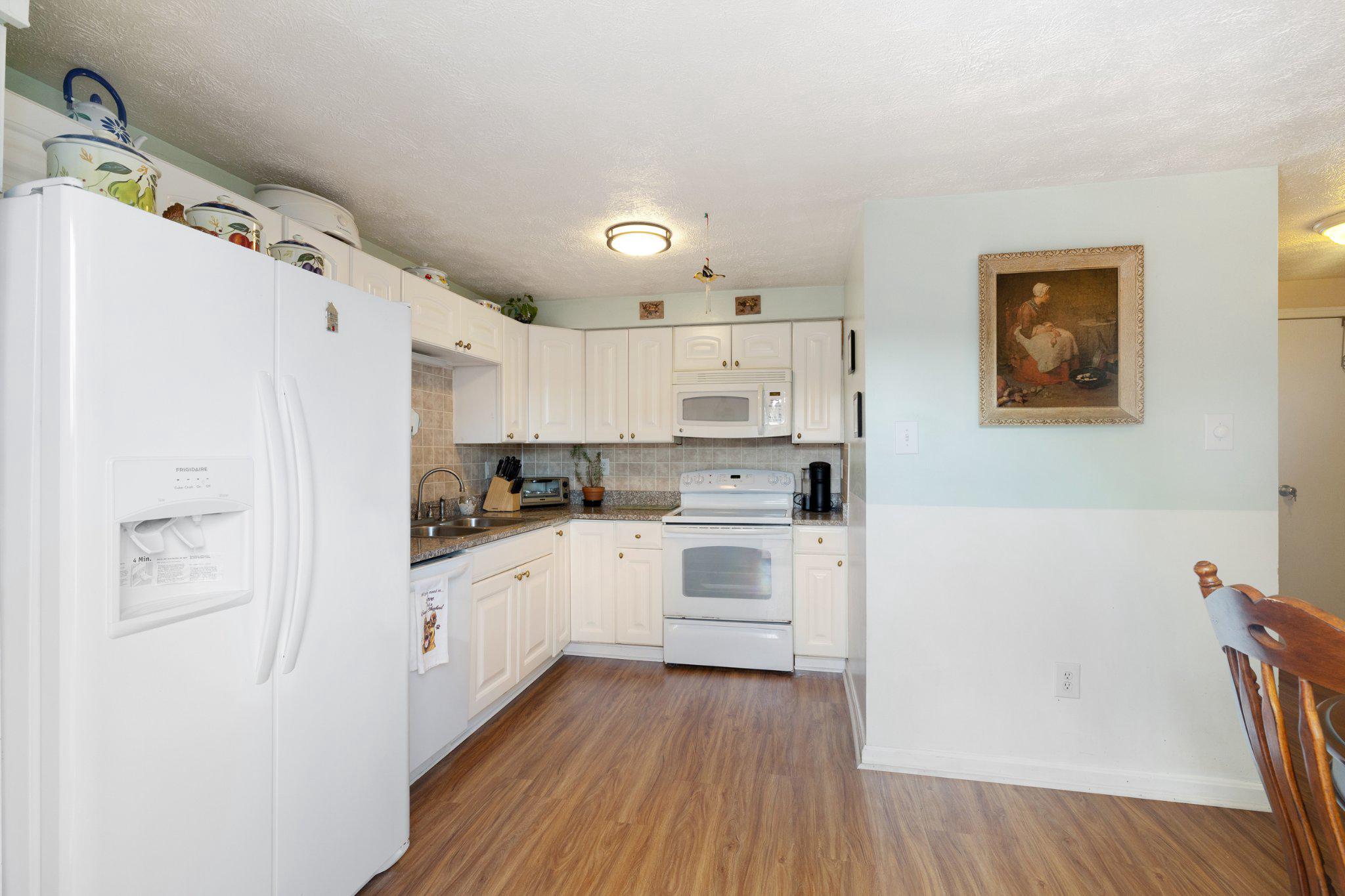 17 Morning Court Rosedale, MD 21237 - Photo 9 of 24 a kitchen with white cabinets and white appliances