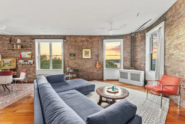 a living room with furniture a flat screen tv and a floor to ceiling window