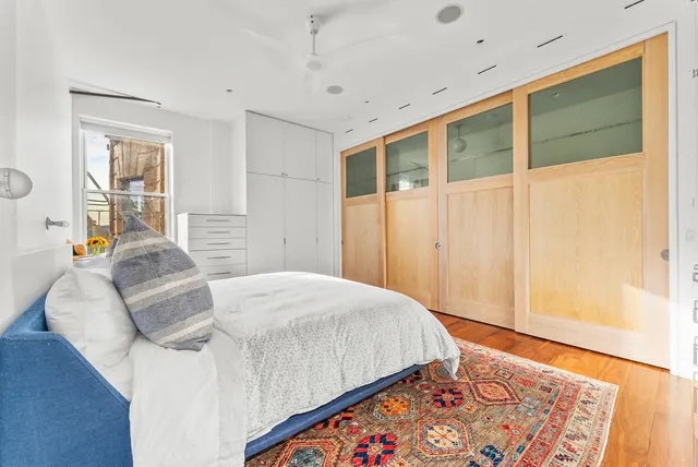 a bedroom with a bed and wooden floor