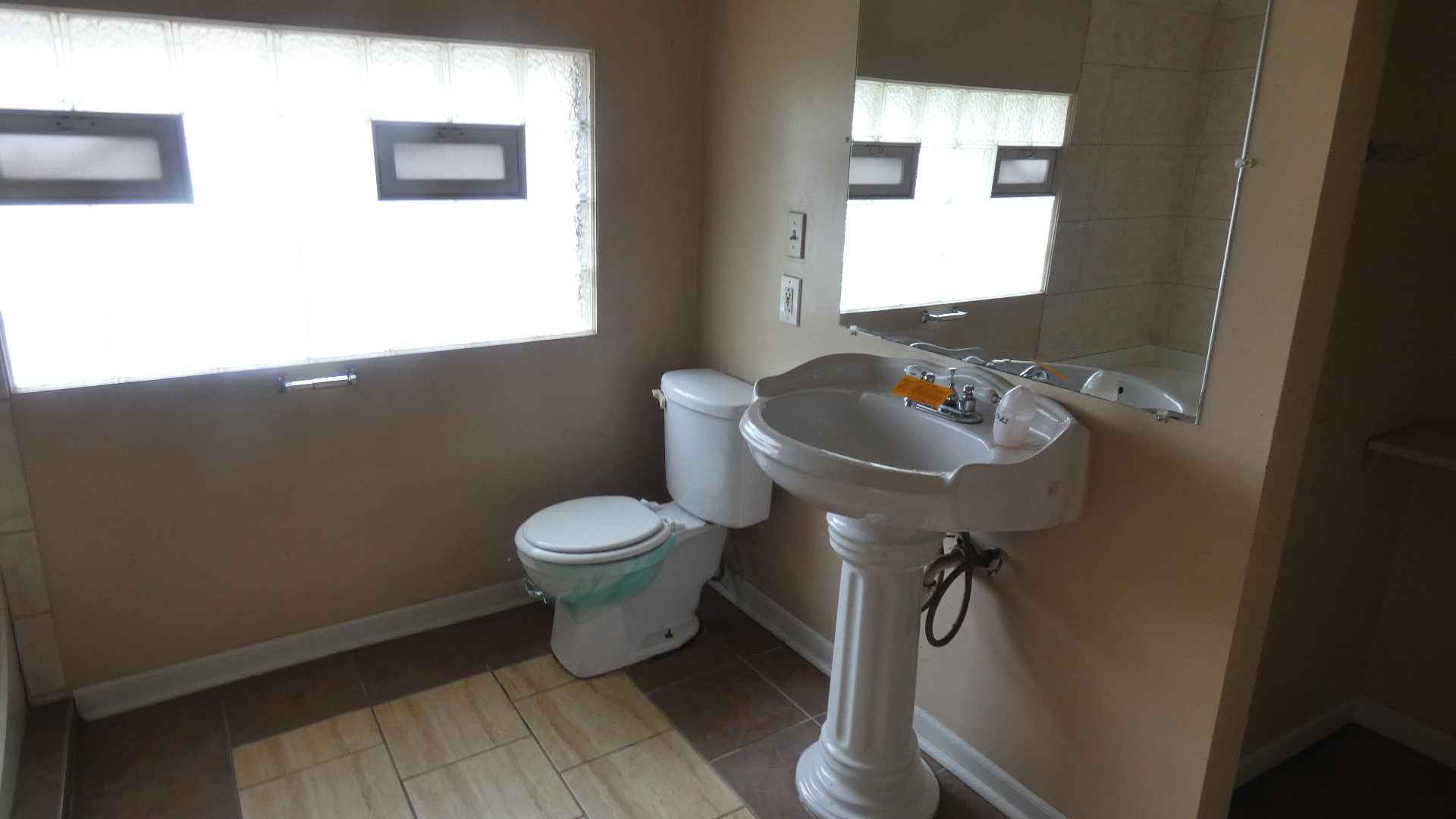 Undisclosed Address Chicago, IL 60628 - Photo 9 of 20 a bathroom with a toilet sink and mirror