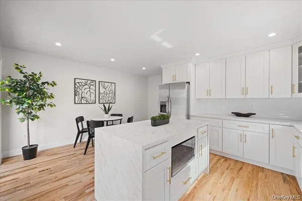 a kitchen with a white cabinets and chairs