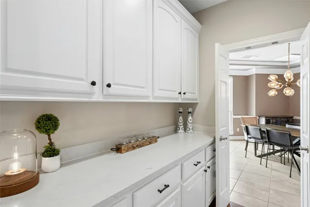 a spacious bedroom with a bed a chandelier and a large window