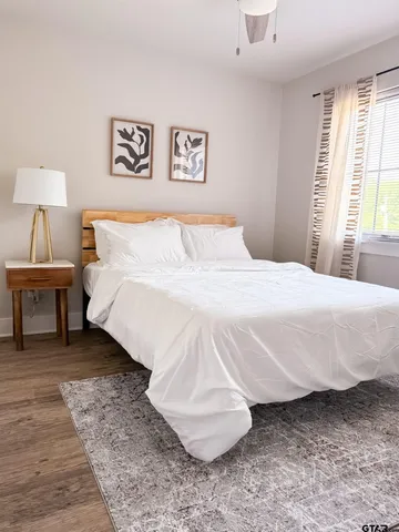 a bedroom with a bed and wooden floor