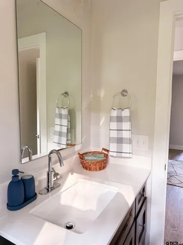 a bathroom with a sink vanity granite tub shower and a mirror