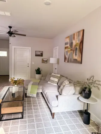 a living room with furniture a flat screen tv and kitchen view