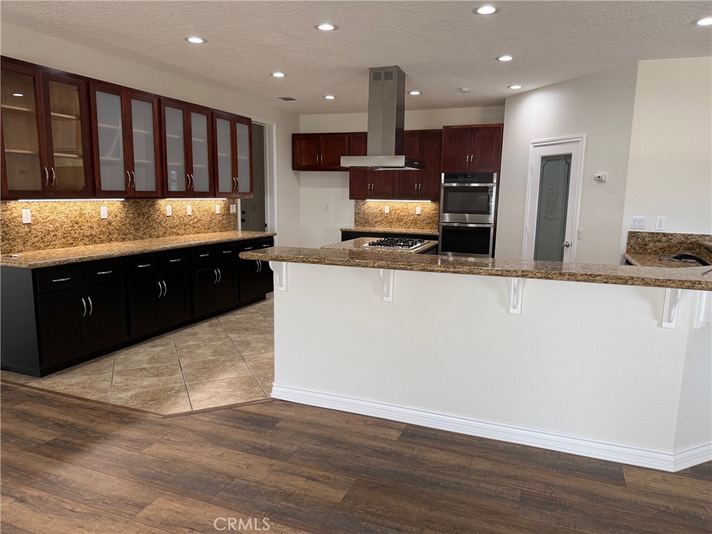 18453 Ranchero Road Hesperia, CA 92345 - Photo 4 of 17 a large kitchen with stainless steel appliances a large counter top a stove a sink and a refrigerator