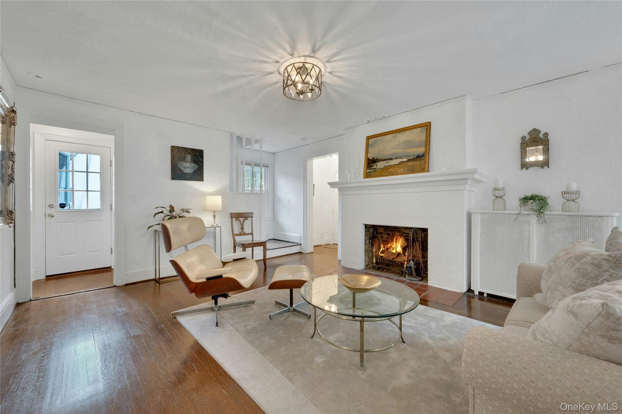1179 Post Road Scarsdale, NY 10583 - Photo 4 of 24 View of the living room with wood burning fireplace and side entry to the house and hallway to the foyer in the background.