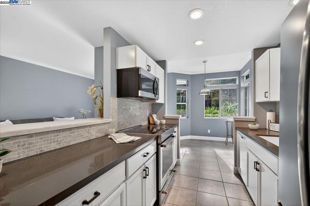 a kitchen with stainless steel appliances granite countertop a sink and a stove