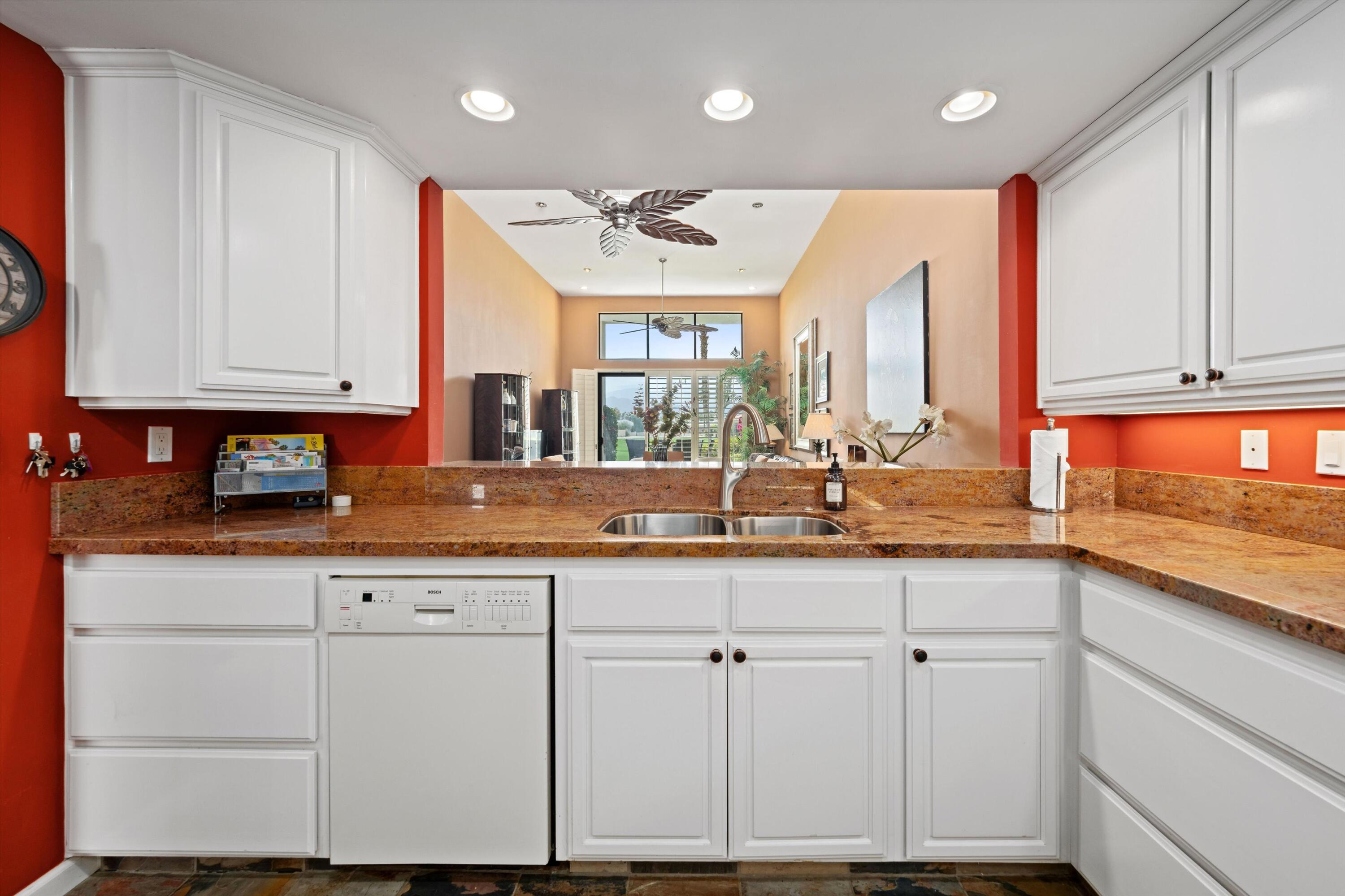 54053 Oak-Hill La Quinta, CA 92253 - Photo 13 of 36 a kitchen with kitchen island granite countertop a sink and white cabinets