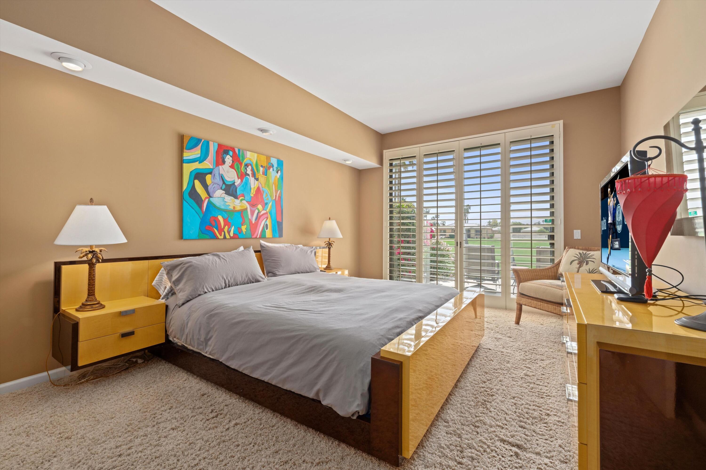 54053 Oak-Hill La Quinta, CA 92253 - Photo 14 of 36 a living room with a bed furniture flat screen tv and a large window